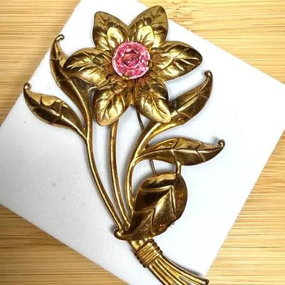 Sterling flower brooch featuring a pink rhinestone center