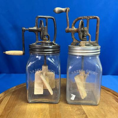 A pair of vintage Dazey glass butter churns with metal mechanisms
