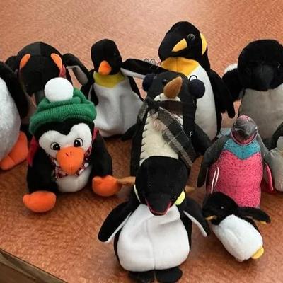 Assortment of Small Penguin Stuffed Animals and Beanies