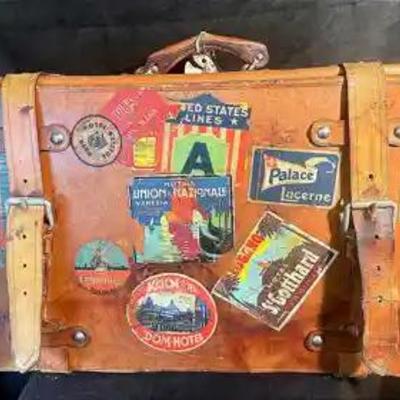 Vintage leather luggage with weathered travel stickers