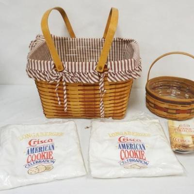 Sale Photo Thumbnail #90: 1090	ASSORTED LONGABERGER BASKETS INCLUDING 1994 HOSTESS BASKET WITH LINER AND PROTECTOR AND CRISCO BASKET SIGNED WITH PROTECTOR, COOKBOOK AND 2 CRISCO APRONS, LARGEST APPROXIMATELY 17 IN X 13 IN X 10 1/2 IN H
