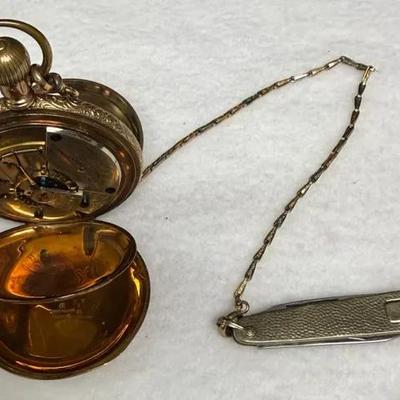 vintage or antique gold hunting case pocket watch with an attached watch chain and small penknife