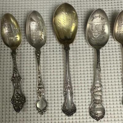 Vintage sterling silver souvenir spoons, likely from the early 20th century, featuring various locat