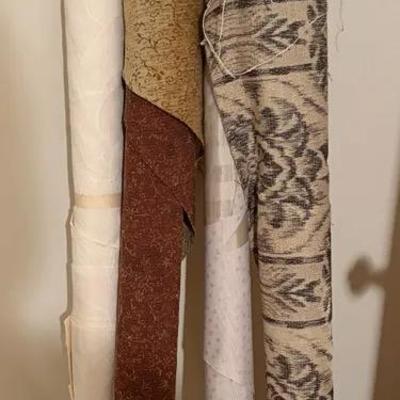 Four Rolls of Assorted Fabric, Including Patterns and Textures