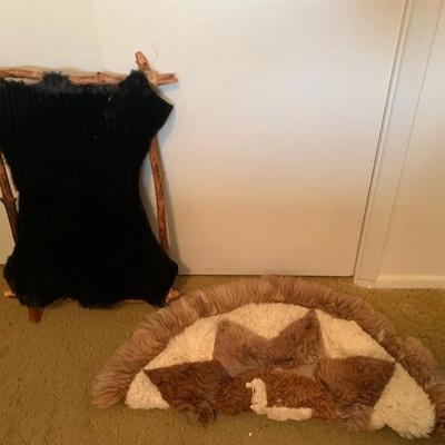 Llama Pelt Rug And Black Pelt On Wooden Stand
