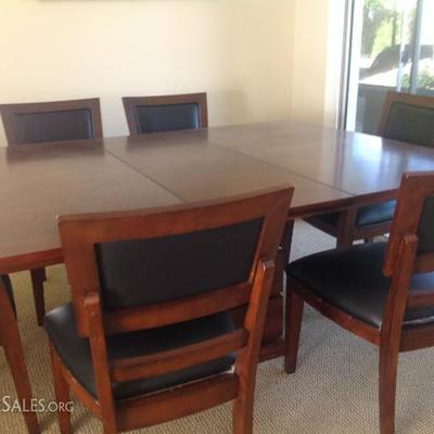 Wood table has 1 leaf
6 chairs with black leather seat and back