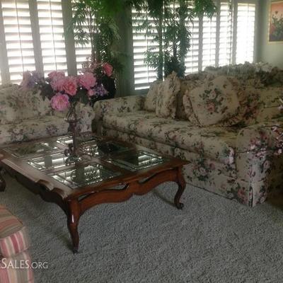 Pair of floral sofas, glass top coffee table
