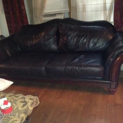 Black leather sofa with wood accents.