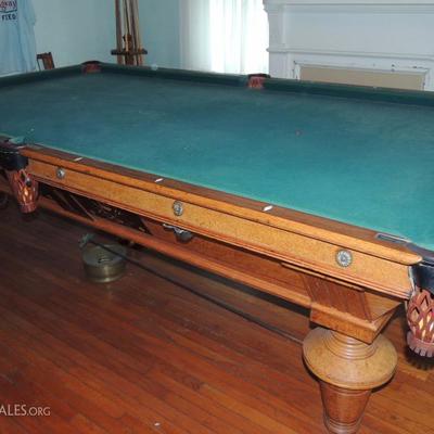 antique Brunswick pool table with wood and ivory inlay.